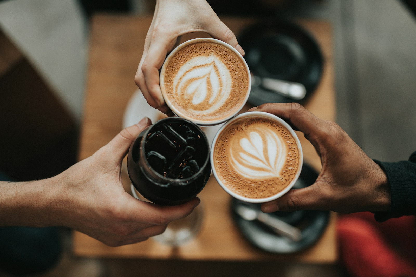 Chávena de café com arte no leite, sobre um pires